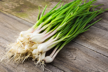  Fresh salad onions on wooden table. 