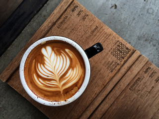 Nice Texture of Latte art on hot latte coffee . Milk foam in heart shape leaf tree on top of latte...