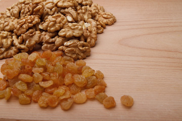 Walnuts and raisin on wooden background