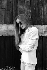 The sexy girl in white trousers about wooden wall