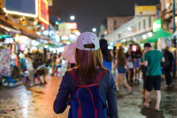 Naklejka premium young woman traveler walking in the Khao San road at night