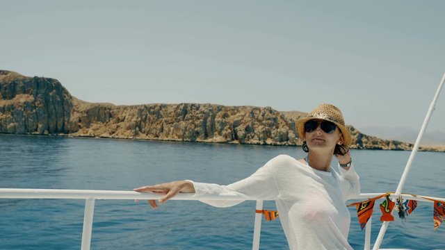Woman enjoying a trip on yacht sitting on deck