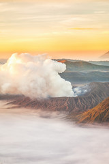 Landscape of Mount Bromo volcano (Mt.) in high angle view with sunrise from viewpoint on Mount Penanjakan located in Bromo Tengger Semeru National Park, East Java, Indonesia.