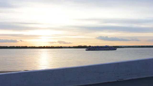 The sunset on the river. The passenger ship sails on the river against the sunset