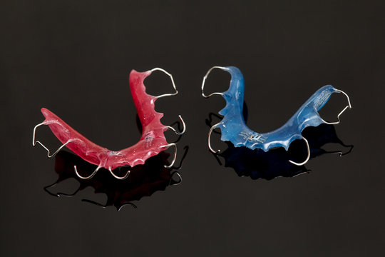 Colorful dental braces or retainers for teeth on glass background
