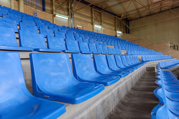 blue plastic seats in a sports hall in a row