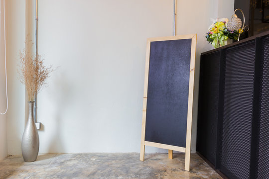 Blank restaurant menu blackboard on the wall with a vase and dry flowers