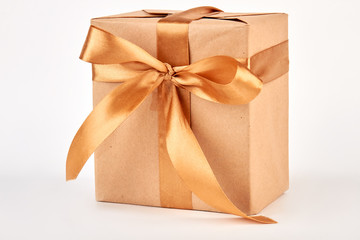 Gift box with golden ribbon. Paper box with bow, white background.