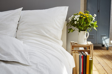 white bed linen morning light fresh flowers industrial