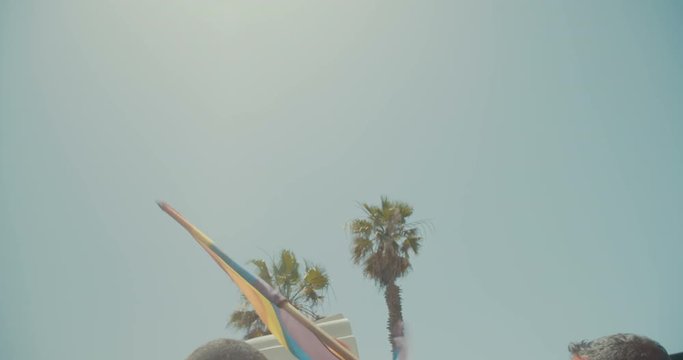 Slow motion shot of the pride flag waving high during a pride parade