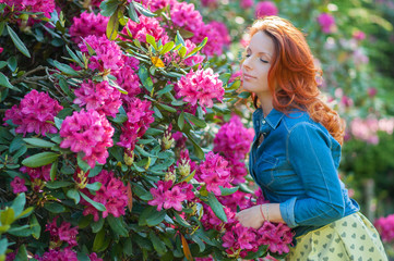 Naklejka premium Young woman at a garden full of flowers