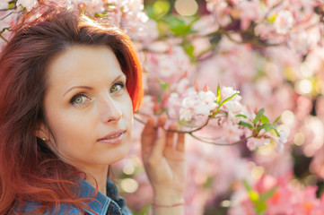 Fototapeta premium Young woman at a garden full of flowers