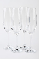 Four fragile champagne glasses isolated. Luxury beverage from crystal flutes.