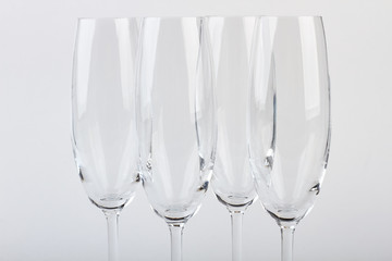 Closeup four champagne goblets. Set of wineglasses, white background. Tableware for company.