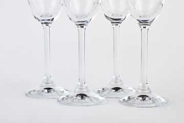 Closeup four champagne goblets. Set of wineglasses, white background. Tableware for company.