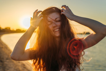 Portrait of a woman with long hair at sunset close-up