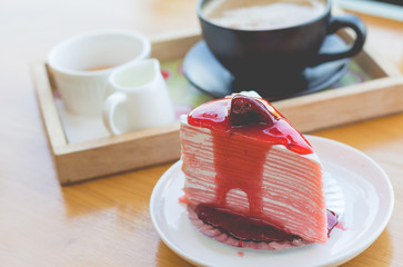 strawberry crape cake and hot coffee in cozy outdoor cafe.(selective focus, vintage effect)