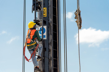 Construction workers wearing safety harness and adequate safety gear while working at high level at...