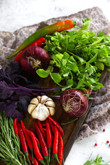 Fresh vegetables, spices and herbs in wooden box in rustic style. Raw organic healthy food concept. Red pepper, onions, garlic, basil and rosemary on dark wooden table,  selective focus