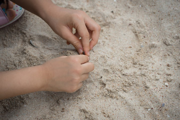 Asian girl playful cheer sand play enjoy smile