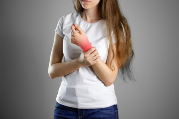 A woman holds by the wrist. The pain in my arm. Sore point highlighted in red. Closeup. Isolated