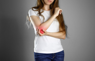 Fototapeta premium A woman holds the elbow. The pain in my arm. A sore point in red. Closeup. Isolated