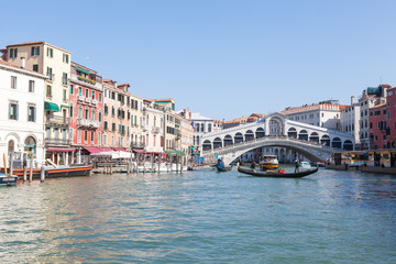 View of Rialto Bridge , Venice , Veneto, Italy from the Grand Canal with a gondola passing in front...