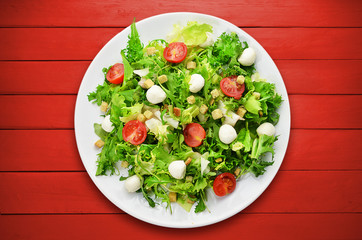 Mixed salad on wooden planks.