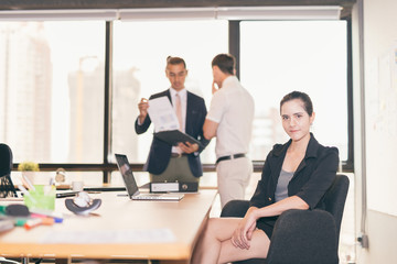 Face of beautiful business woman with her staff, people group in background at modern bright office indoors city view focus on women