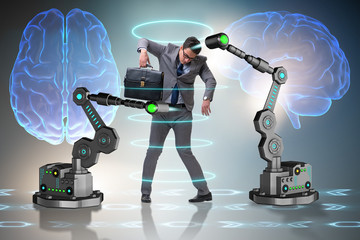Businessman being manipulated by robotic arms