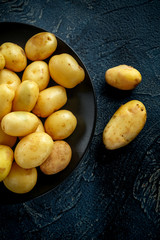 raw baby new potatoes in black plate
