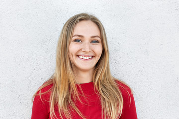 Cheerful blonde woman with freckled face, charming eyes and sincere smile having pleased look while...