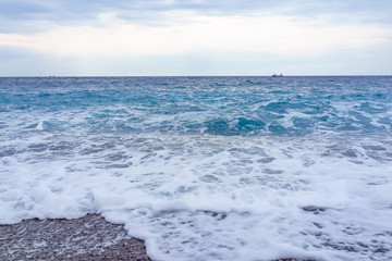 selective focus Soft gentle waves with foam in blue ocean italy coast, summer vacation as background
