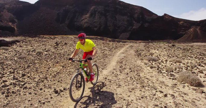 Mountain bike - man biking on MTB cycling trail. Man cycling enjoying healthy lifetyle and outdoor sports activity. Lanzarote, Canary Islands, Spain. RED EPIC SLOW MOTION.