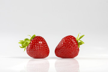 Two red  strawberries isolated on white background.