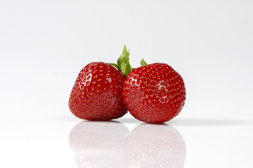 Two red  strawberries isolated on white background.