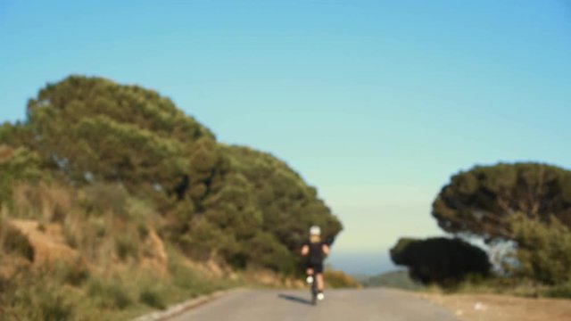 Unfocused shot of woman on professional road bike sprinting out of the shot, winning competition to prove female athletes are strong and powerful, finishes the race with sign of success