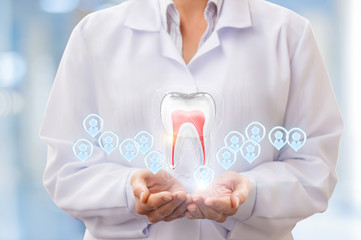 Tooth and patients in the hands of a dentist .