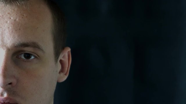 portrait of a young man staring at camera,black background.