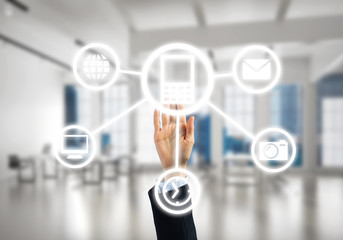 Modern office interior and close of businesswoman hand choosing symbol on application interface