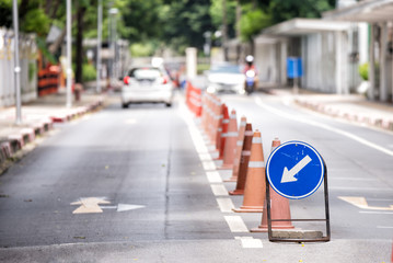 Arrow Sign on the Road with Blurred Vehicle Background in the City