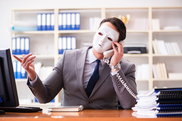 Businessman with mask in office hypocrisy concept