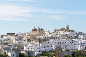 Fototapeta na wymiar Ostuni, Italy - May 26, 2017: Panoramic view of the white city from the fields nearby