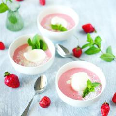 Cold creamy strawberry soup with a scoop of ice cream and mint
