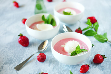 Cold creamy strawberry soup with a scoop of ice cream and mint