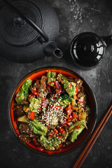 Noodles with vegetables and meat on a dark background, Asian food, Top view, Selective focus