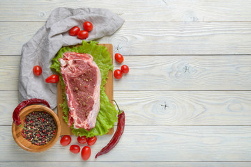raw meat with ingredients on a wooden background