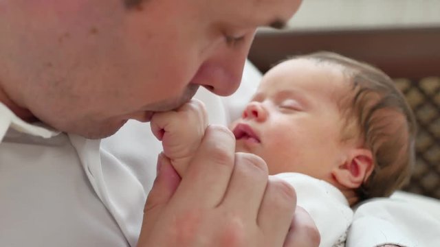Pope kisses hand of baby, baby is sleeping on dad hands, children room