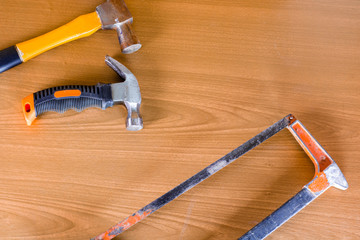 Set of tools over a wood panel with space for text,set of construction tools,hammer , nail ,screwdriver,saw, copy  space background