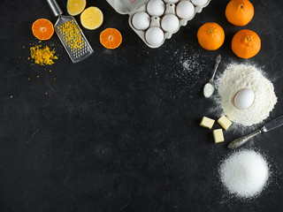 Ingredients for citrus cake on a dark stone background, Top view